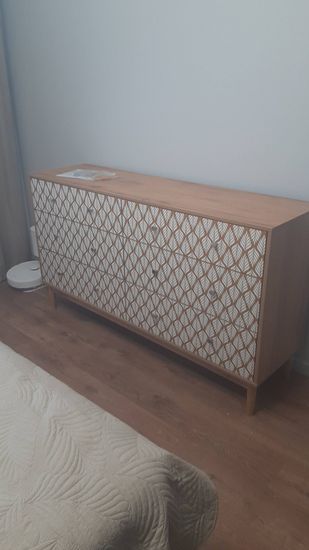 Собран деревянный комод с узорчатыми фасадами, установлены ящики, прикреплены ножки, проверена устойчивость, закреплены ручки, обеспечена функциональность и эстетичность мебели.