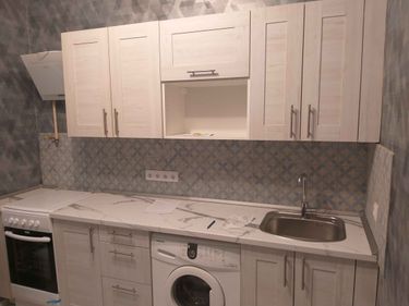 Установлены шкафы, закреплена столешница, подключена мойка, смонтирована варочная панель, размещена вытяжка. Завершена установка плитки на фартук, подключены розетки и бытовая техника.