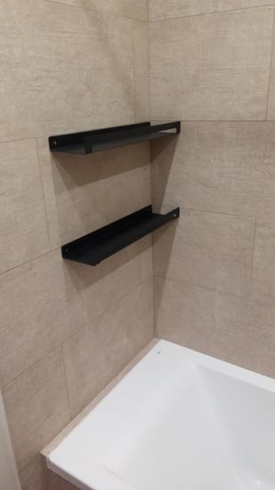 Установлены две черные полки на стену в ванной. Аккуратное крепление, ровное расположение, надежная фиксация. Полки идеально вписываются в интерьер, создавая дополнительное место для хранения.
