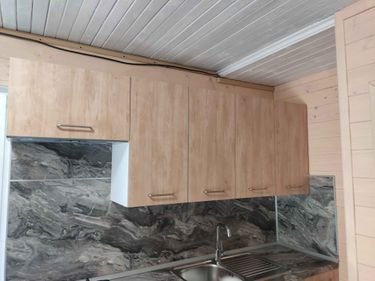 Установлены шкафы, закреплены фасады, смонтирована столешница, подключена мойка, установлены ручки, выполнен монтаж фартука. Все элементы собраны и закреплены, кухня готова к использованию.