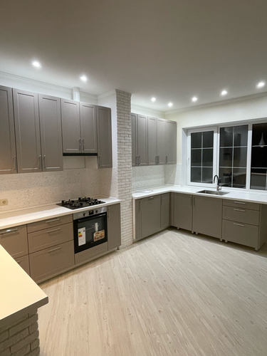 Выполнена подгонка кухонной поверхности, обеспечивающая идеальное прилегание к стенам и мебели, с учетом всех углов и вырезов под технику, что создает гармоничный и функциональный интерьер.