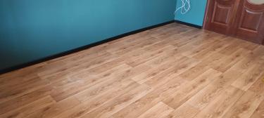 Покрытие ровно уложено на подготовленное основание, стыки аккуратно подогнаны, материал плотно прилегает к поверхности, обеспечивая гладкость и эстетичный вид. Завершено оформление плинтусами.