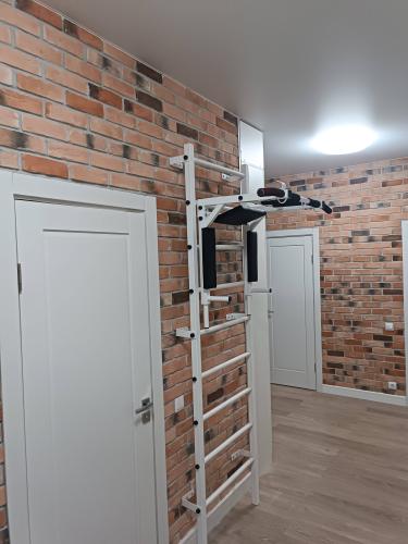 Закреплен спортивный снаряд на кирпичной стене. Установлены крепления, обеспечивающие надежность и безопасность. Все элементы выровнены и проверены на прочность.