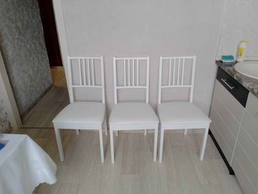 Собраны три белых стула, установлены спинки, закреплены сиденья, проверена устойчивость. Все детали соединены, конструкция завершена, готова к использованию.