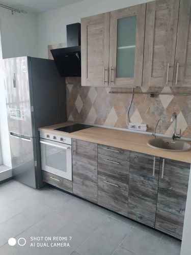 Установлены шкафы, закреплены фасады, смонтирована столешница, подключена техника, установлена мойка, смеситель, вытяжка. Завершена отделка фартука, подключены розетки.