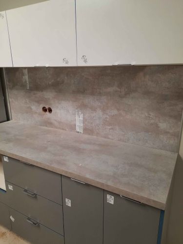 Установлены шкафы, закреплены фасады, смонтирована столешница, подключены коммуникации, выровнены поверхности, навешены дверцы, установлены ручки, выполнена отделка стен.