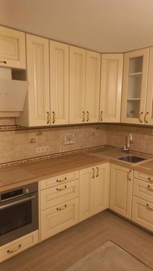 Установлены шкафы, закреплены фасады, смонтирована столешница, подключена мойка, встроена варочная панель, установлена вытяжка, добавлены ручки, завершена отделка стен.