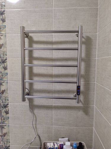 Электрический полотенцесушитель закреплен на стене, подключен к сети, проверена работоспособность, обеспечена безопасность, устройство готово к использованию.