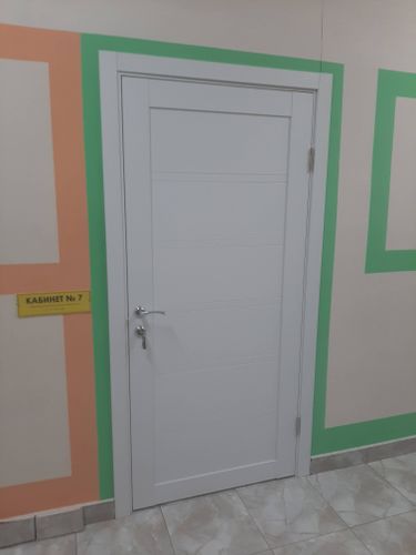 На деревянной двери установлено запорное устройство. Выполнены точные вырезы, закреплены ручки, обеспечена плавная работа механизма. Установка завершена аккуратно и надежно.