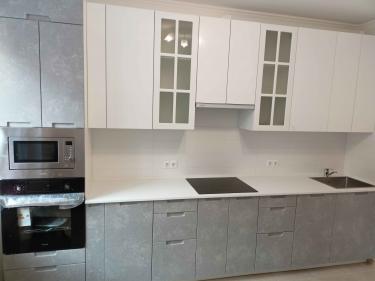 Закончена инсталляция гладкой поверхности из композита на кухонные шкафы, выполнены вырезы для мойки и варочной панели, все элементы надежно закреплены, швы аккуратно обработаны.