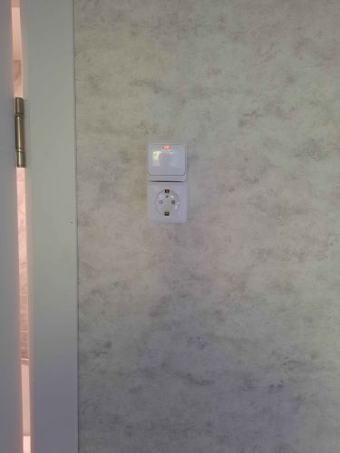 Электроприборы подключены, розетка установлена на стене, проводка скрыта, выключатель закреплён. Все элементы надежно зафиксированы, обеспечивая безопасное использование.