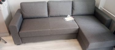 Собран угловой диван: установлены подлокотники, прикреплены спинки и сиденья, закреплены ножки. Все детали надежно соединены, обеспечивая комфорт и устойчивость конструкции.