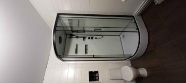 Установлена современная душевая конструкция с гидромассажной системой. Подключены водопроводные коммуникации, закреплены стеклянные панели, смонтированы полки и дверцы.