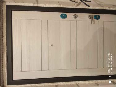 Дверь покрыта панелями из МДФ, придающими современный вид. Установлены новые замки и ручка. По периметру добавлена изоляция для улучшения тепло- и звукоизоляции.