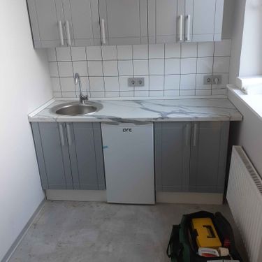 Выполнена установка столешницы с вырезом под раковину. Поверхность точно подогнана к стенам, обеспечивая аккуратное прилегание. Завершено подключение сантехники.