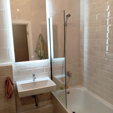 Изображение ванной комнаты с установленным электрическим полотенцесушителем. Завершены работы по монтажу устройства, подключению к электросети и проверке его функционирования.