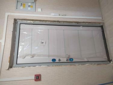 Дверь покрыта панелями из МДФ, установлены ручки и замки, обрамление завершено, защитная пленка временно оставлена для сохранности поверхности.