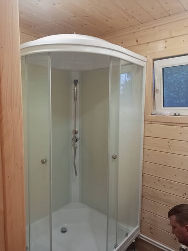Установлена душевая конструкция с низким основанием, подключены водопроводные коммуникации, закреплены стеклянные двери, проверена герметичность, завершены отделочные работы.