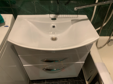 Установлена новая раковина, подключены водопроводные трубы и слив, закреплены смеситель и сифон, проверена герметичность соединений, проведено тестирование на утечки, завершена отделка.