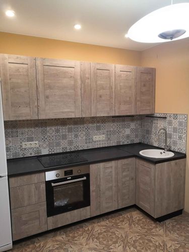 Установлены шкафы, смонтирована столешница, подключена варочная панель и раковина. Завершена отделка фартука плиткой, обеспечена функциональность кухни.