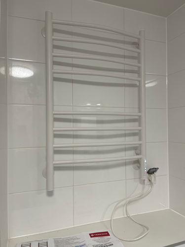 Закреплен электрический полотенцесушитель на стене, подключен к розетке, проверена работоспособность, обеспечена надежная фиксация, соблюдены меры безопасности.