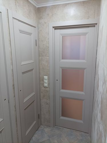 Установлена новая деревянная дверь, закреплены петли, врезан замок, отрегулирована фурнитура, выровнена коробка, выполнена отделка откосов, проверена плавность открывания и закрывания.