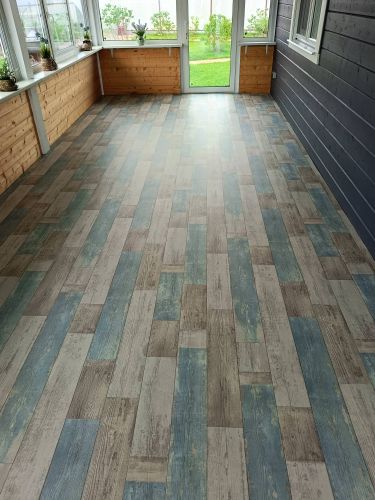 На полу ровно уложено покрытие, создающее эффект деревянных досок. Цвета гармонично сочетаются, создавая уютную атмосферу в помещении. Работа выполнена аккуратно и качественно.