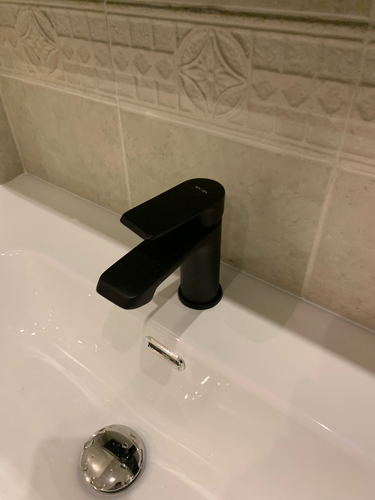 Установлен новый черный кран на раковине в ванной. Завершены работы по подключению водопровода и герметизации соединений. Обновленный элемент гармонично вписался в интерьер.