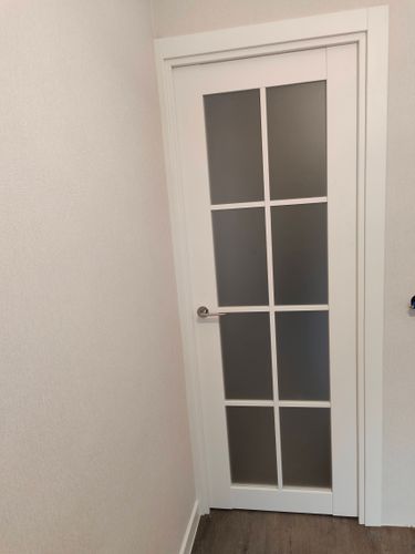 Изображена установленная дверь-гармошка. Завершены работы по монтажу, включая крепление направляющих, фиксацию петель, регулировку створок, проверку плавности хода и установки ручек.