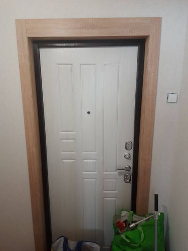 На деревянной двери выполнено аккуратное врезание замка. Проведены работы по подготовке отверстия, установка механизма и проверка его функционирования. Дверь закрывается плавно и надежно.