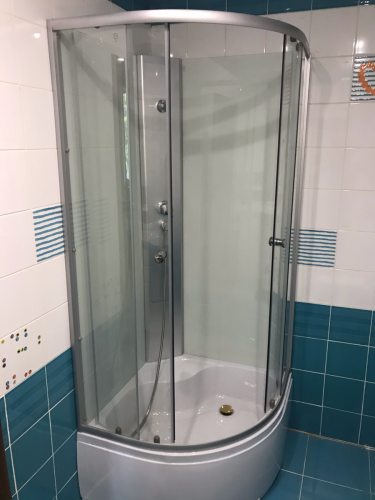 Установлена душевая конструкция с низким основанием, закреплены стеклянные панели, подключены водопроводные линии, герметизированы стыки, проверена функциональность системы.