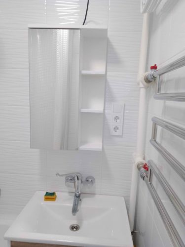 Установлен шкаф с зеркалом в ванной комнате. Закреплены крепления, выровнена конструкция, подключена подсветка. Все элементы надежно зафиксированы, обеспечена безопасность использования.