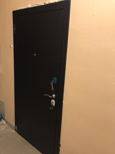 Установлена новая металлическая дверь, закреплена в проеме, отрегулированы петли, проверена работа замка, зазоры заполнены монтажной пеной для герметичности и звукоизоляции.