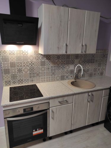 Установлены шкафы, смонтирована столешница, врезана варочная панель, подключена мойка, закреплены ручки, собран фартук. Завершена установка вытяжки.