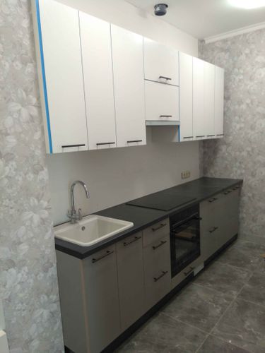 Установлены шкафы, закреплены фасады, смонтирована столешница, подключена мойка, размещена варочная панель, встроена духовка, прикреплены ручки, завершена отделка стен.