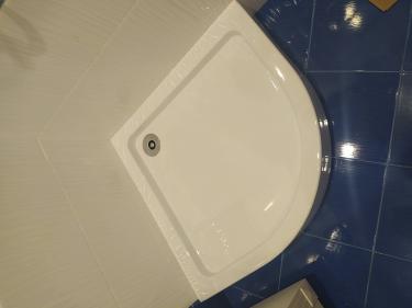 Установлен слив в полу под плитку, обеспечена герметичность, выровнено основание, подключена канализация, уложена плитка, проверена система на утечки, завершены отделочные работы.