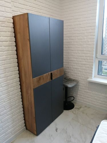 Собран шкаф: установлены дверцы, закреплены боковые панели, прикреплены ручки, выровнены полки, проверена устойчивость, отрегулированы петли, обеспечена надежность конструкции, завершена сборка.