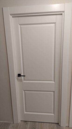 Установлены новые наличники на дверь, обеспечивая аккуратный и завершённый вид. Все элементы подогнаны точно, без зазоров, создавая гармоничный внешний облик и улучшая эстетику помещения.