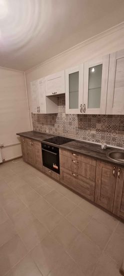 Установлены шкафы, закреплены фасады, смонтирована столешница, подключена варочная панель, установлена мойка, выполнена укладка плитки на фартук, размещены ручки на дверцах.