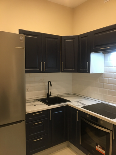 На изображении показана кухня с установленной столешницей, которая была аккуратно подогнана под размеры помещения, включая вырезы для мойки и варочной панели.