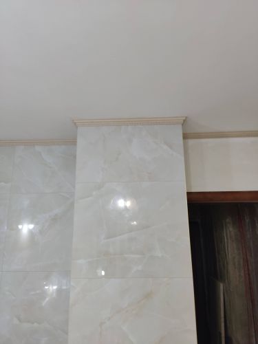 Установлен скрытый плинтус, идеально вписанный в интерьер. Элементы аккуратно закреплены, обеспечивая плавный переход между стенами и потолком. Завершенный вид создает ощущение целостности пространства.