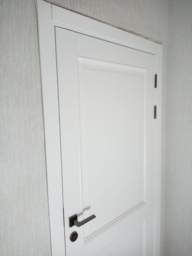 Установлена белая дверь с ручкой и петлями, закреплена коробка, отрегулировано полотно, выполнена отделка откосов.