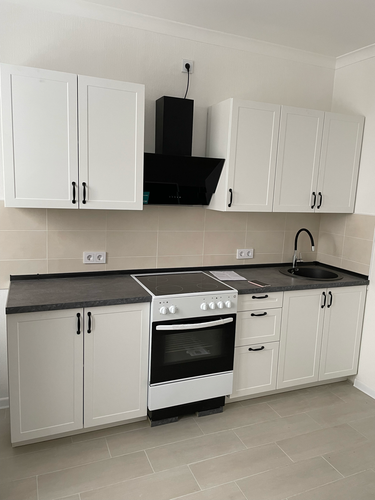 На кухне установлена столешница с вырезами для варочной панели и мойки, идеально подогнанная по размерам. Все элементы гармонично сочетаются, создавая завершенный и аккуратный вид.