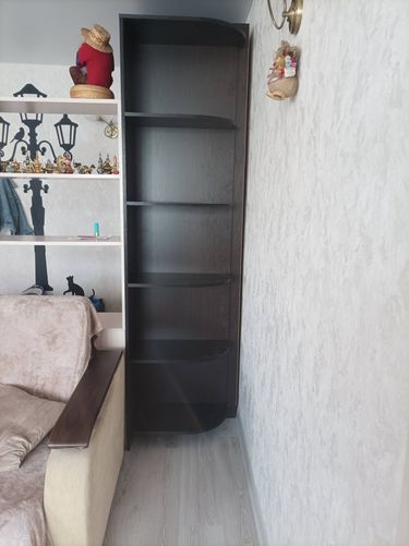 Собран новый угловой стеллаж из темного дерева, установлен в комнате. Полки надежно закреплены, конструкция устойчива. Работа выполнена аккуратно, мебель гармонично вписана в интерьер.