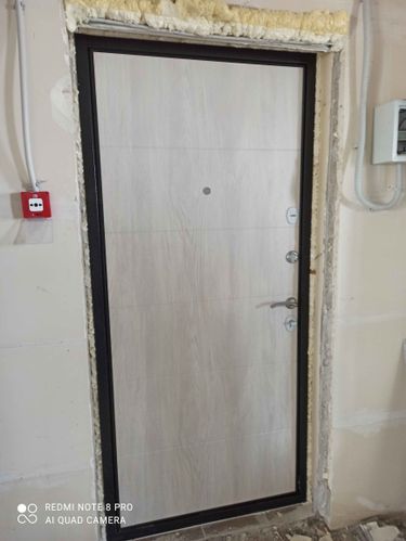 Установлена новая дверь, закреплена в проеме, обработаны швы монтажной пеной для герметичности и утепления. Установлены ручки и замок, проверена функциональность.