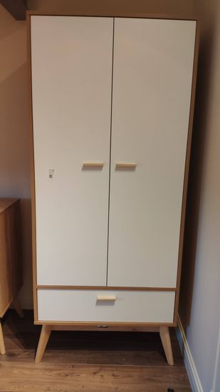 Собран шкаф с двумя дверцами и выдвижным ящиком. Установлены ручки, закреплены петли, выровнены ножки. Все элементы соединены, конструкция устойчива и готова к использованию.