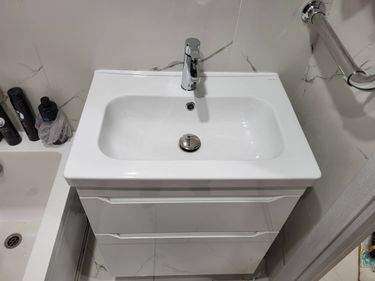 Установлена новая раковина с подключением к водопроводу и канализации, закреплен смеситель, герметизация швов, проверена герметичность соединений, выполнена чистовая отделка.