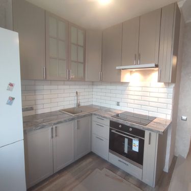 Установлены шкафы, смонтирована столешница, подключена варочная панель и вытяжка, закреплены фасады, установлена мойка, подключены светильники, выполнена укладка фартука.