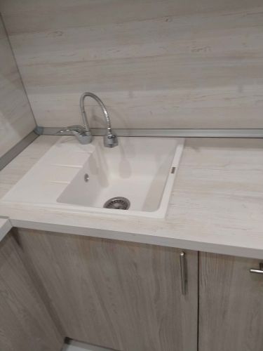 Установлены шкафы, закреплена столешница, врезана мойка, подключен смеситель. Все элементы аккуратно подогнаны, обеспечена функциональность и эстетика.