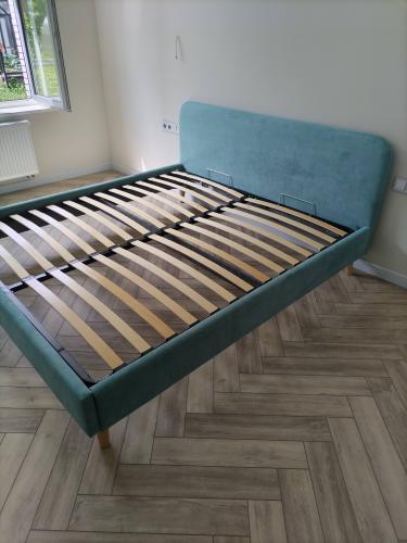 Собрана двуспальная кровать: установлены ножки, закреплено изголовье, уложены ламели. Конструкция устойчива и готова к эксплуатации.